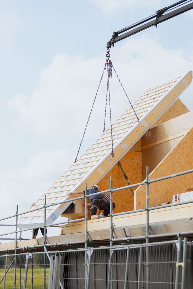 Prefab dakelement hangt aan de kraan boven de woning in 't Zandt
