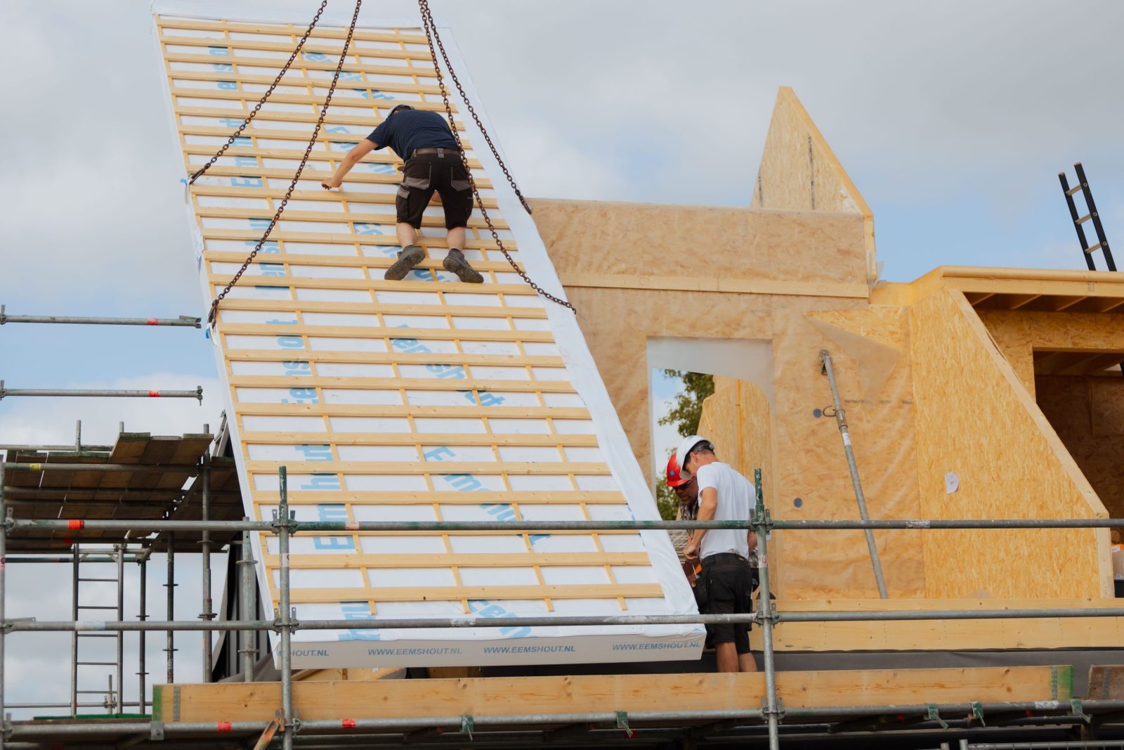 Monteur op het prefab dak van de woning in 't Zandt